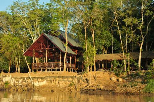 a house on the shore of a body of water at Borneo Natural Sukau Bilit Resort in Bilit