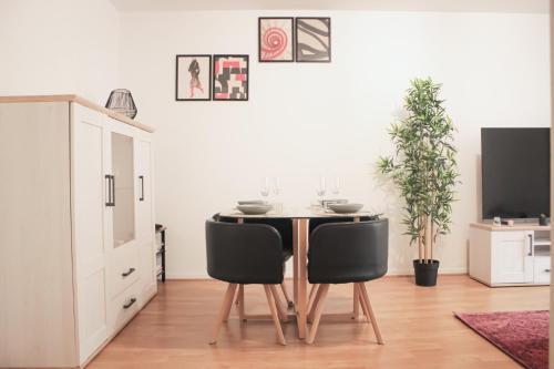 a dining room with a table and two chairs at *Claire : Appartement avec *balcon + parking* in Mantes-la-Jolie