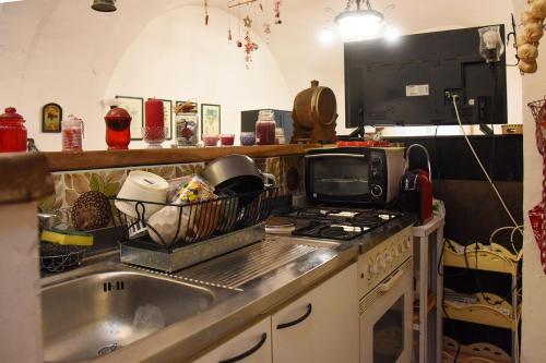 cocina con fregadero, fogones y microondas en Il Cortile nel Borgo, en Lanciano