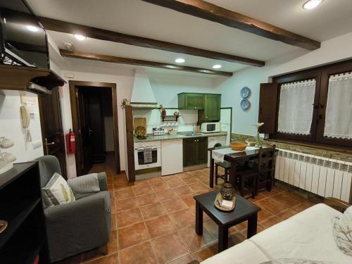 cocina y sala de estar con sofá y mesa en Apartamentos Rurales Casa Pachona, en Puerto de Vega