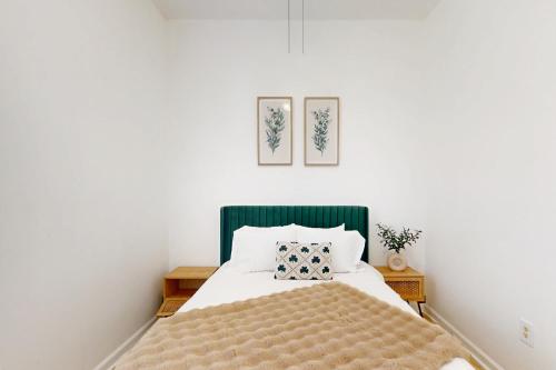 a bedroom with a bed with a green headboard at Modern Memories, Unit B in Savannah