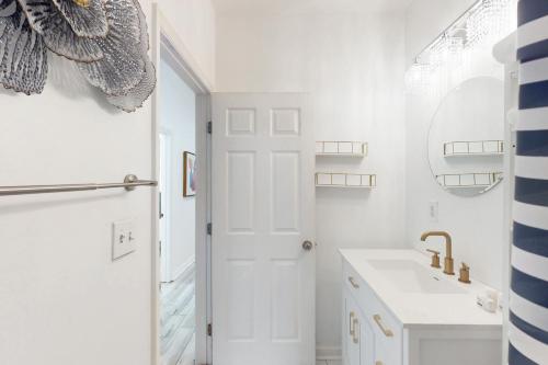 a white bathroom with a sink and a mirror at Modern Memories, Unit B in Savannah