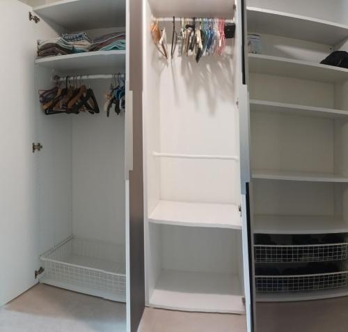 un vestidor con estanterías blancas en Studio tout confort à 5 mn métro+parking gratuit en Montreuil