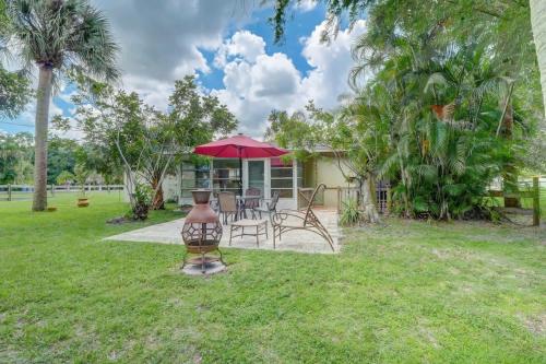 ボニータ・スプリングスにあるSuper Private Home With Great Outdoor Spaceのパティオ(テーブル、赤い傘付)
