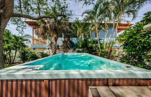 a swimming pool in a backyard with a fence and trees at Snook Haven in Clearwater Beach