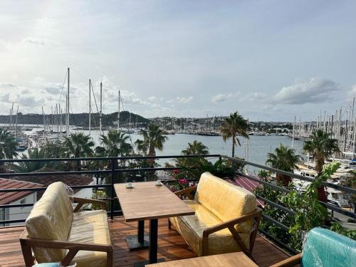 a balcony with a table and chairs and a harbor at By Muhtar Hotel Bodrum in Bodrum City