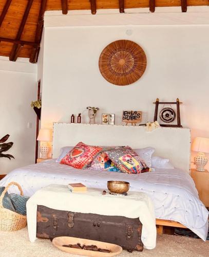 a bedroom with a bed with a trunk on the floor at En las Nubes in Medellín