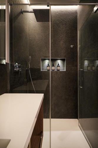 a bathroom with a shower with a glass door at SalvatoreHomes - Pure Luxury in the Centre of Bardolino with Pool & Private Garden - Casa Olivia - a 5 Star Luxury Collection at Lake Garda in Bardolino