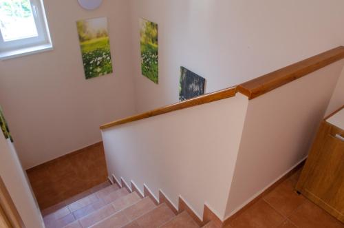 a staircase in a home with white walls and brown floors at Bánki Vendégház in Bánk