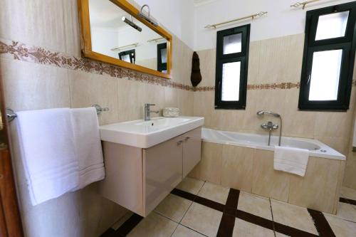 a bathroom with a sink and a tub and a mirror at Villa Courrier in Tremestieri Etneo