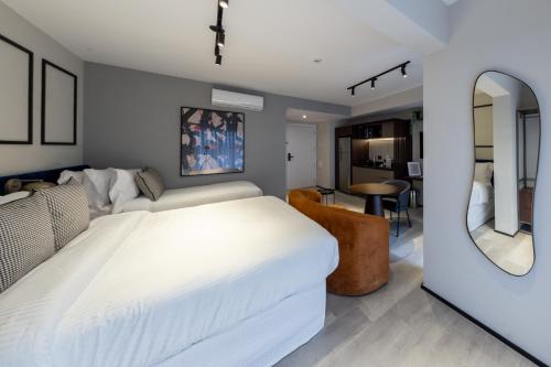 a bedroom with a large white bed and a mirror at Charlie On The Parc Ibirapuera Hotel in Sao Paulo