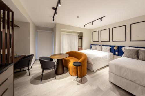 a hotel room with a bed and a table and chairs at Charlie On The Parc Ibirapuera Hotel in Sao Paulo
