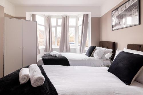 a bedroom with two beds and a window at The Heart of Crawley in Crawley