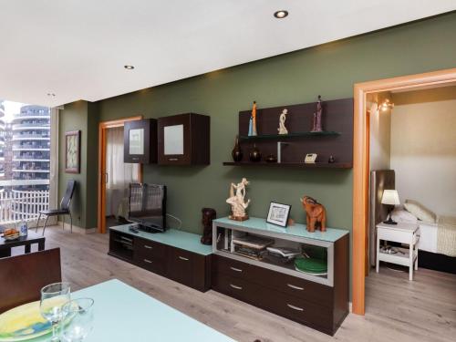 a living room with a green wall with shelves and a table at Apartment Sants-Montjuic Rambla Badal by Interhome in Barcelona