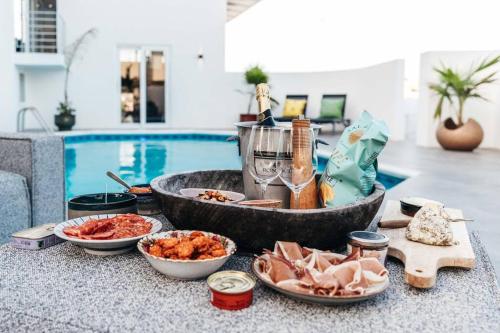 a buffet of food on a table next to a pool at Vakantievilla Jan Sofat, Curaçao in Willemstad