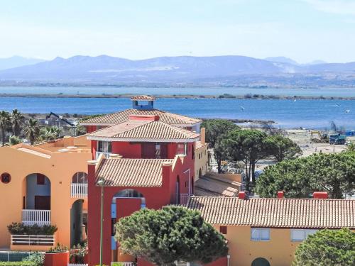 a red and orange house with the ocean in the background at Apartment Soleil Levant 1 et 2-2 by Interhome in Le Barcarès