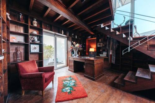 a living room with a staircase and a chair and a desk at Vakantievilla Jan Sofat, Curaçao in Willemstad