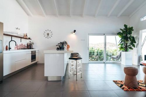 a white kitchen with a counter and a table at Vakantievilla Jan Sofat, Curaçao in Willemstad