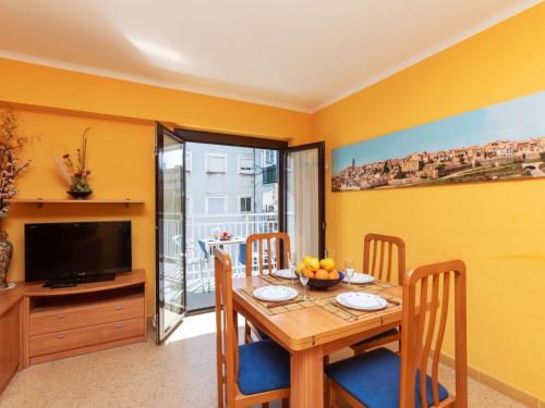 uma sala de jantar com uma mesa e uma televisão em Apartment Flandria-1 by Interhome em Salou