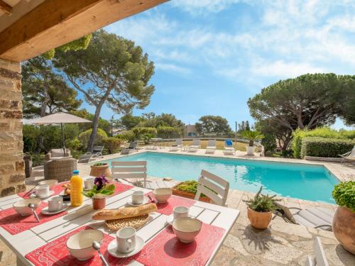 einen Esstisch im Freien mit Poolblick in der Unterkunft Holiday Home La Crischona by Interhome in Les Issambres