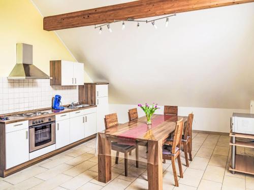 eine Küche mit einem Holztisch und Stühlen in der Unterkunft Apartment Greiweldenger Leit As by Interhome in Greiveldange