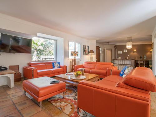 un salon avec des chaises orange et une table dans l'établissement Holiday Home Le Murier by Interhome, à Fréjus