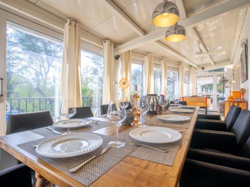 une salle à manger avec une longue table en bois et des verres à vin dans l'établissement Holiday Home Le Murier by Interhome, à Fréjus
