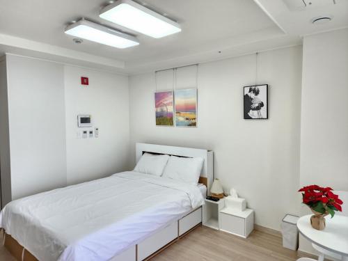 a white bedroom with a bed and a sink at Sokcho Summitbay 1209 "Ocean View" in Sokcho