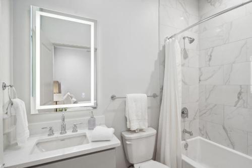 a bathroom with a sink and a toilet and a mirror at The Eleanor New Orleans in New Orleans