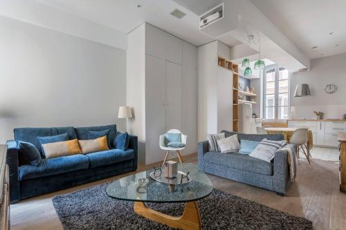 a living room with two blue couches and a table at Appartement 50m² - proche de Bellecour/2 personnes in Lyon