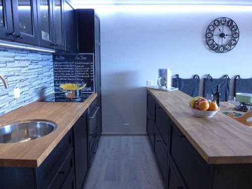 a kitchen with a sink and a clock on the wall at Apartment Ambassadeur 3 by Interhome in Villars-sur-Ollon