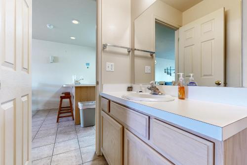 a bathroom with a sink and a mirror at Harbor Village Pool Building Condo 104 in Garden City