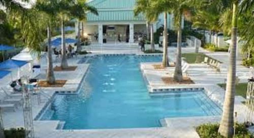 een groot zwembad met palmbomen in een resort bij Villa Vista-2 Story w 3Bdrms & Golf View in Miami
