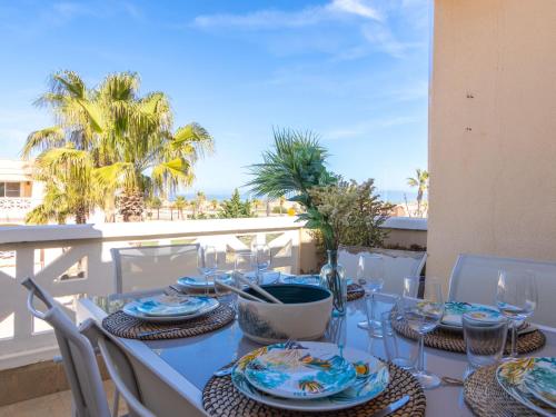 デルテブレにあるApartment Res Mediterraneo-7 by Interhomeのテーブル(皿付)、バルコニー(ワイングラス付)
