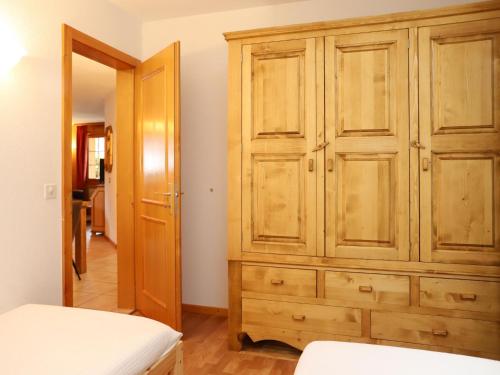 a bedroom with a wooden cabinet and a bed at Apartment Colline 1 by Interhome in Champex