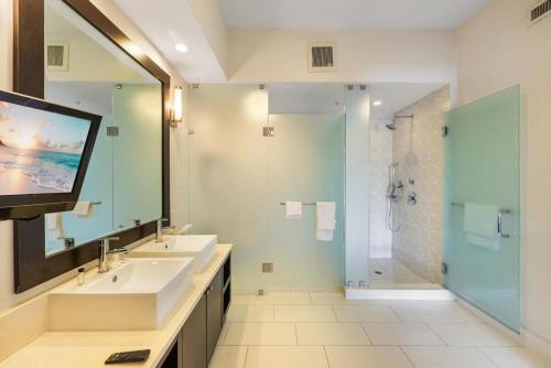 een badkamer met 2 wastafels, een douche en een televisie bij Villa Vista-2 Story w 3Bdrms & Golf View in Miami