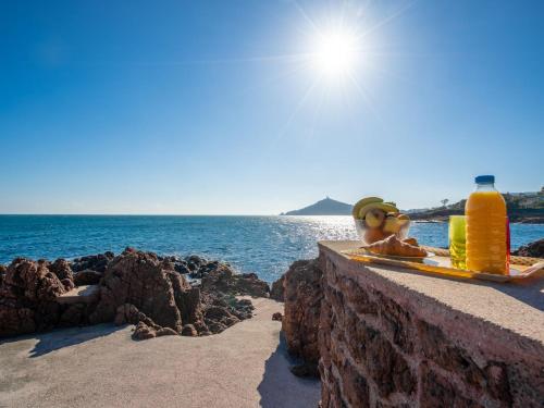 une personne assise sur un grand livre à côté de l'océan dans l'établissement Holiday Home La Proue by Interhome, à Agay