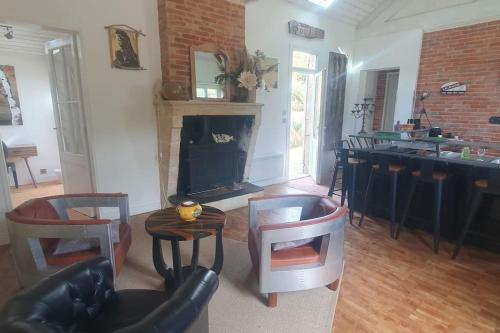 - un salon avec une cheminée, une table et des chaises dans l'établissement Villa proche plage de l'Amélie - 3057, à Soulac-sur-Mer