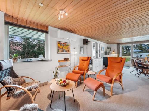 a living room with orange chairs and a table at Holiday Home Moreen - 200m to the inlet by Interhome in Vemb