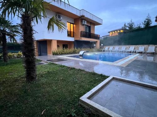 una casa con piscina frente a una casa en DSF Villas & SPA A16, en Kırkpınar