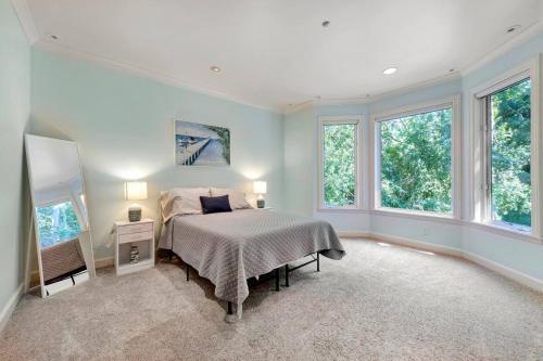 ein Schlafzimmer mit einem Bett in einem Zimmer mit Fenstern in der Unterkunft Morgan Hill Elegance Spa & Pool Retreat in Morgan Hill
