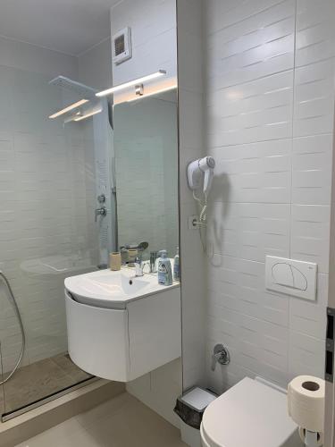a white bathroom with a sink and a toilet at Apartament Vila Brana Sibiu Selimbar str Nicolae Brana Nr 63 Ap 4 in Şelimbăr