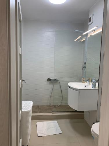 a white bathroom with a sink and a shower at Apartament Vila Brana Sibiu Selimbar str Nicolae Brana Nr 63 Ap 4 in Şelimbăr