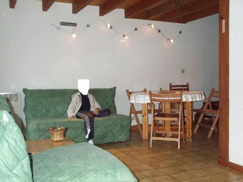 a man sitting on a couch in a living room at Chalet de 2 chambres avec terrasse et wifi a Cauterets in Cauterets