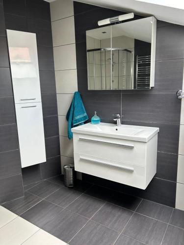y baño con lavabo blanco y espejo. en Apartament Bobrzańska en Świdnica