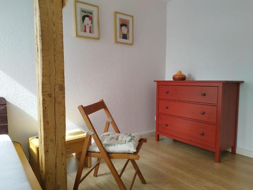a bedroom with a wooden chair and a dresser at Flussperle in Coswig