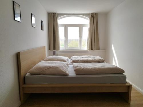 two beds in a bedroom with a window at Flussperle in Coswig