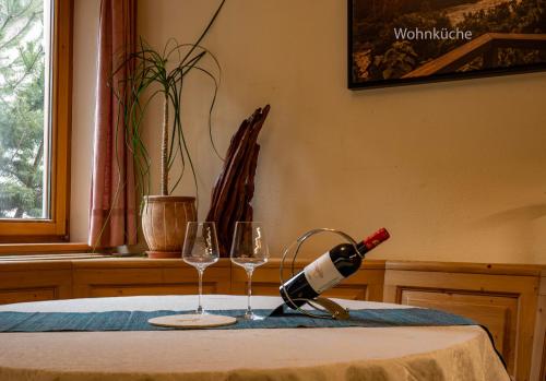 a bottle of wine and two glasses on a table at GORI Boutique Apartments – Tirol in Reutte