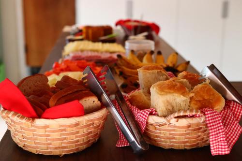 two baskets of bread and food on a table at Garden 437 Suítes in Florianópolis