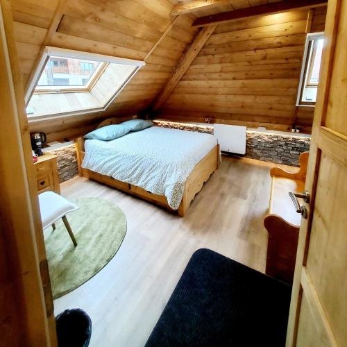 - une chambre dans une cabane en rondins avec un lit et une fenêtre dans l'établissement DEL VINO bar à vin & guitares Appartement Sauna Terrasse Garage, à Orchamps-Vennes